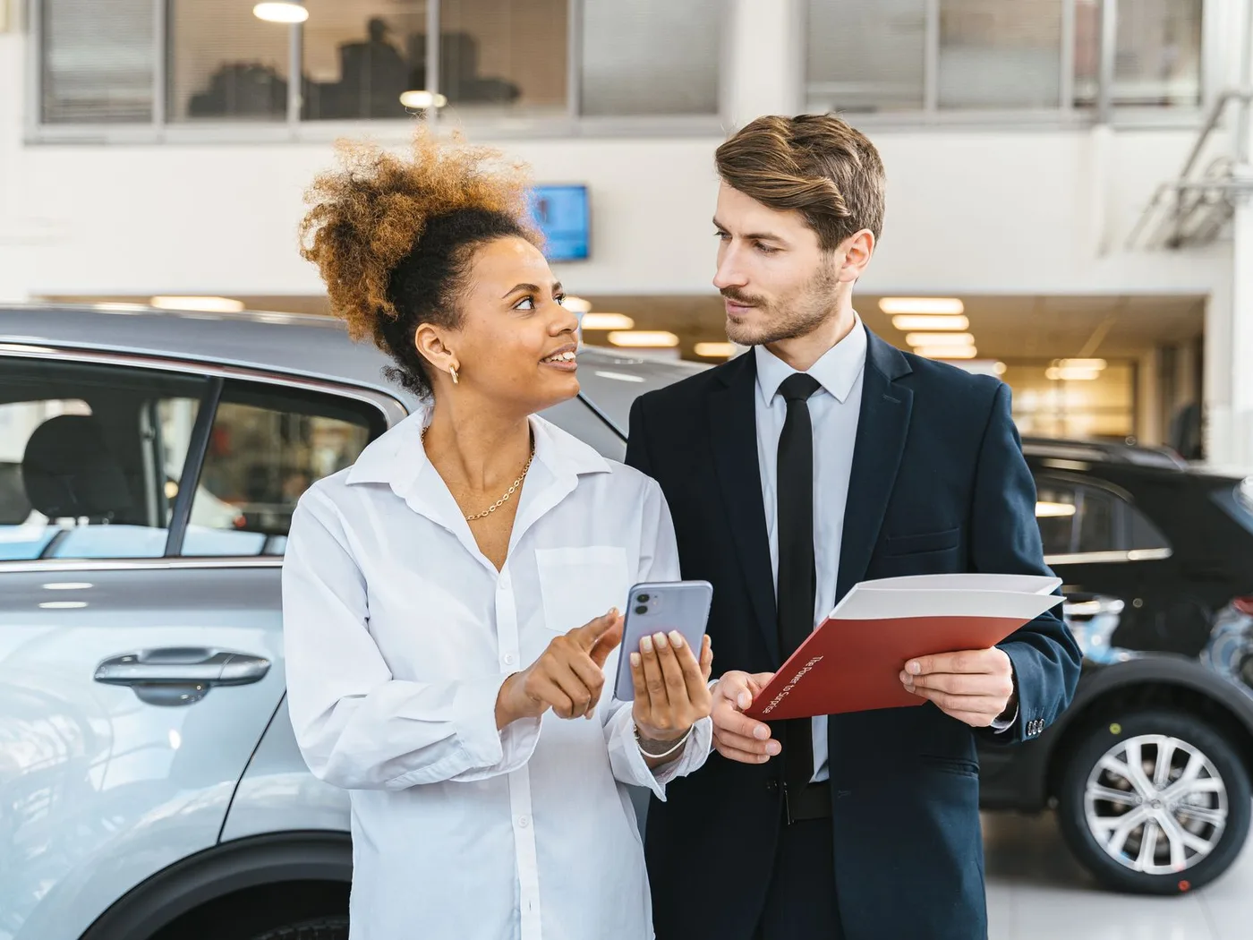 Customers discussing a vehicle finance agreement at a dealership
